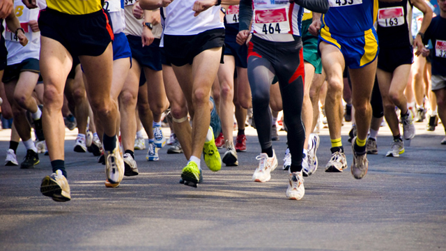 detail of the legs of runners at the start of a marathon race